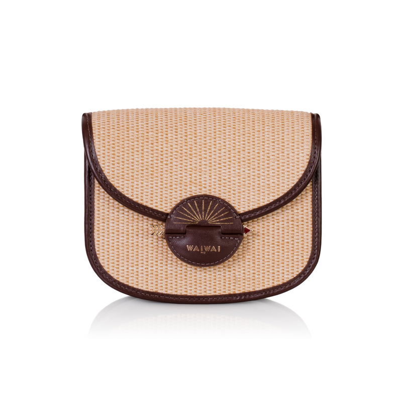 Bolsa Waiwai em rattan natural com acabamento em couro marrom e fecho redondo central em resina marrom com detalhe dourado.