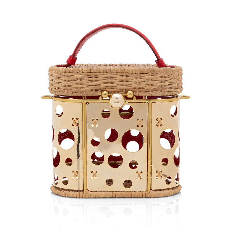 Bolsa artesanal em rattan com painel frontal em dourado vazado de círculos, alça curta em couro vermelho e fecho dourado metálico.