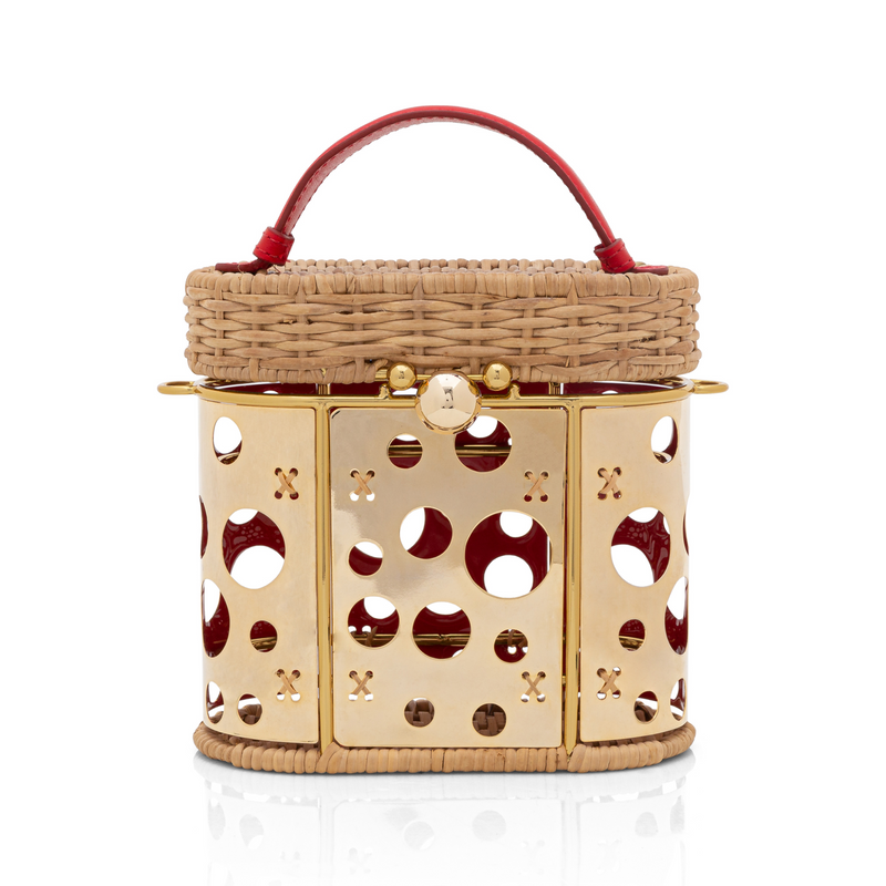 Bolsa estruturada em rattan com painel frontal dourado vazado em círculos, alça curta em couro vermelho e fecho dourado.