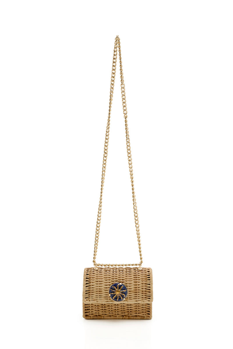 Bolsa estruturada em rattan natural, decorada com detalhe azul marinho e sol dourado, alça longa dourada em corrente.