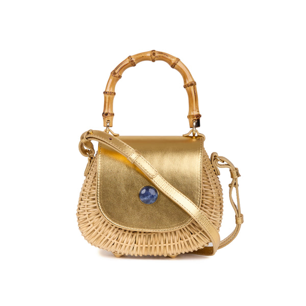 Bolsa artesanal em rattan, com tampa em couro dourado metalizado, pedra azul no centro e alça de bambu.