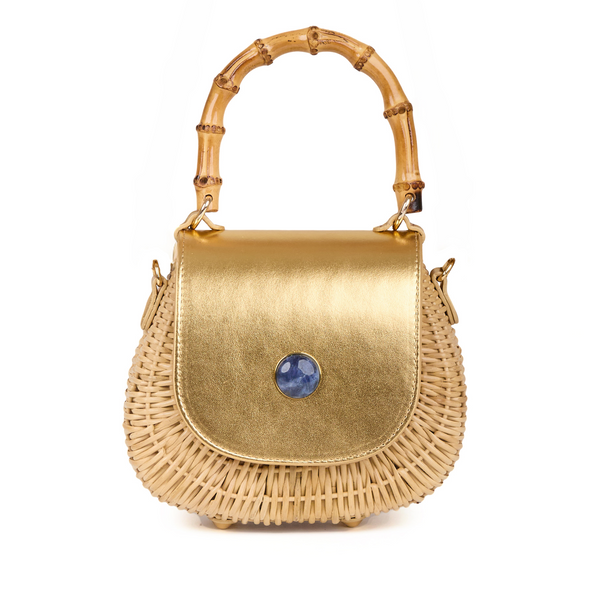 Bolsa estruturada em rattan natural com flap em couro dourado metalizado, detalhe central de pedra azul arredondada e alça superior em bambu.