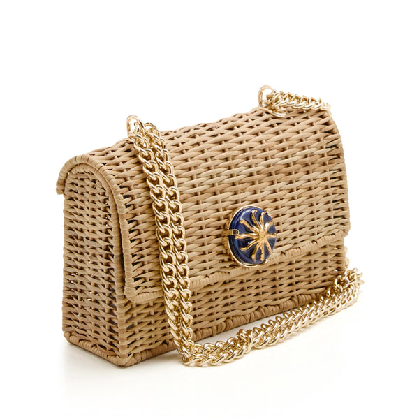 Bolsa estruturada em rattan natural, versão grande, com detalhe azul marinho e sol dourado no centro, alça de corrente dourada.