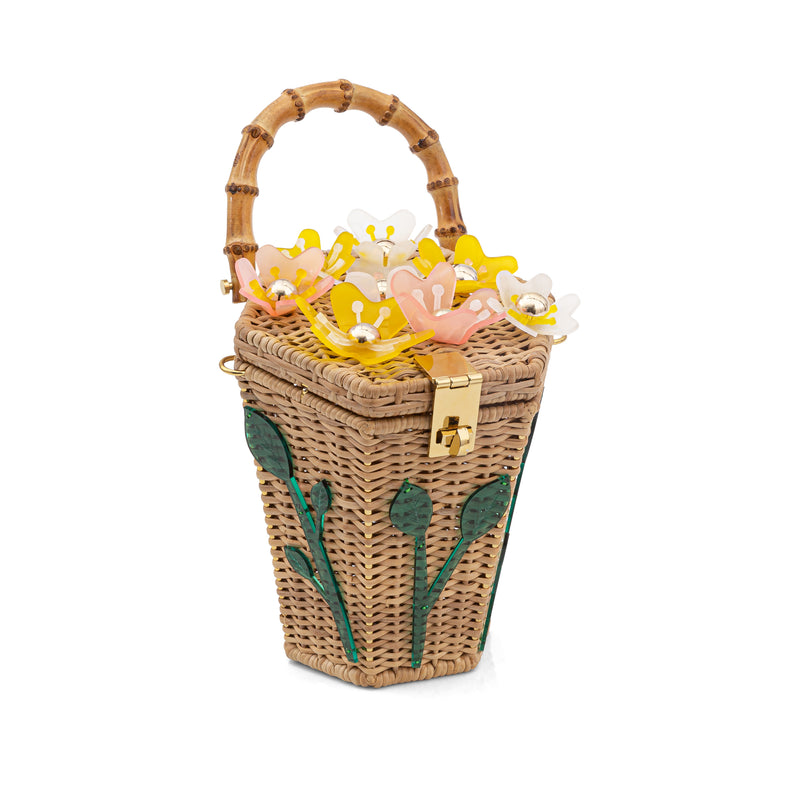 Bolsa em rattan estruturado com aplicação de flores coloridas na tampa, folhas verdes na lateral, fecho metálico dourado e alça em bambu.