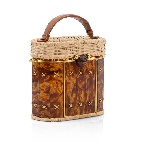 Bolsa em rattan estruturada com painel frontal em acrílico marrom marmorizado, alça curta em couro marrom e acabamentos dourados.