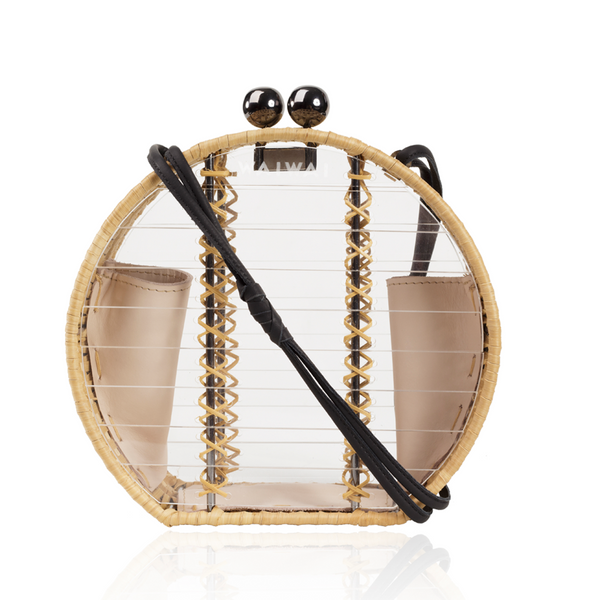Bolsa redonda em acrílico transparente com laterais em rattan, detalhe de costura em X dourado, alça longa em couro preto e fecho esférico metálico.