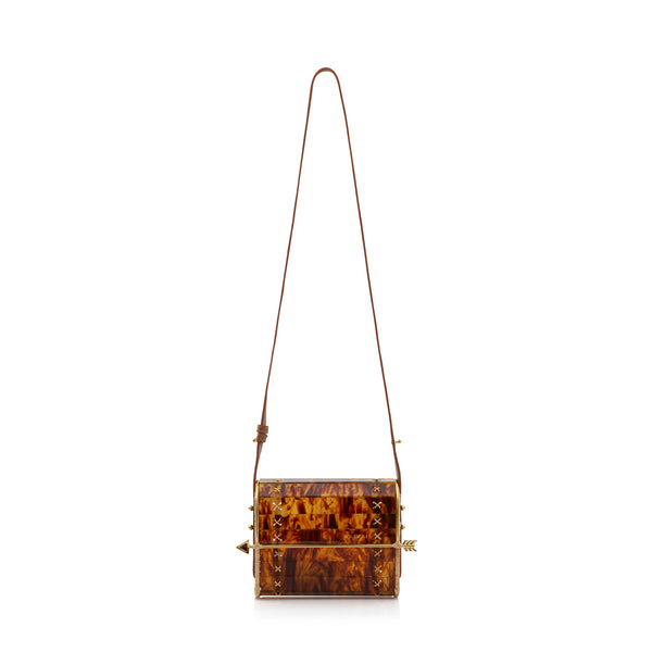 Bolsa em acrílico tartaruga estruturada com laterais em palha natural, fecho dourado em formato de flecha e amarrações artesanais nas laterais.