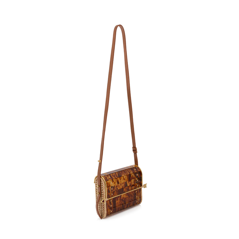 Bolsa estruturada em acrílico tartaruga com laterais em palha, design rígido com fecho de flecha dourada e amarrações manuais nas laterais.