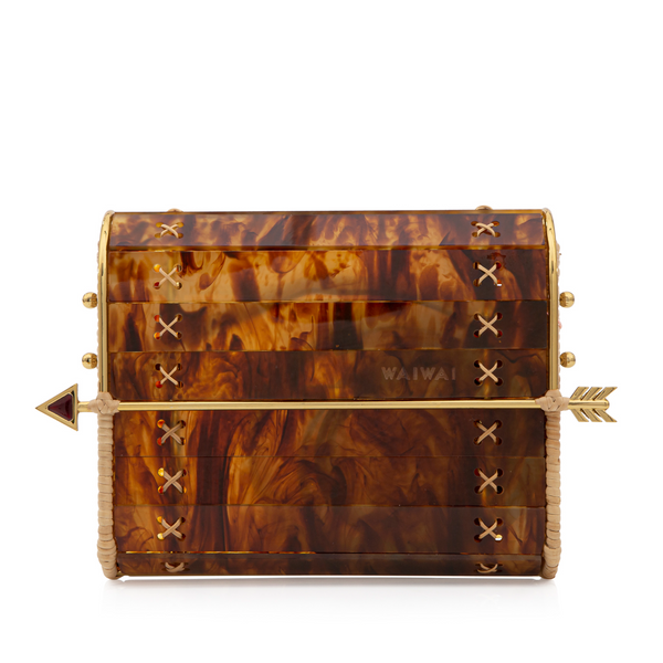 Bolsa estruturada em acrílico de tartaruga com laterais em palha natural e fecho em formato de flecha dourada. Design rígido e elegante, com detalhe artesanal de amarrações laterais.