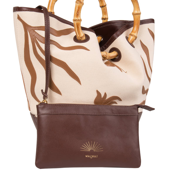 Bolsa tote de tecido cru com bordados em marrom, base lisa marrom e alça estruturada em bambu.