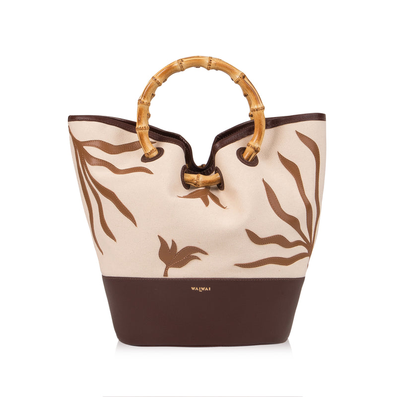 Bolsa tote em tecido cru com bordados marrons, base em marrom sólido e alça estruturada em bambu.