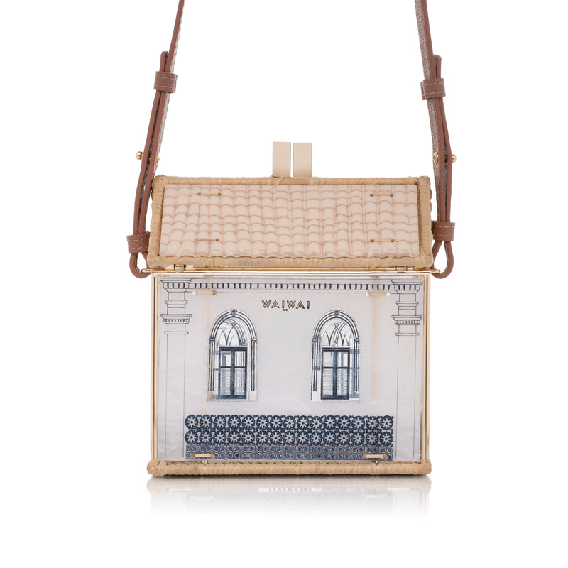 Bolsa em formato de casa, feita em acrílico e vime, com janelas arqueadas e azulejos inspirados na arquitetura colonial.
