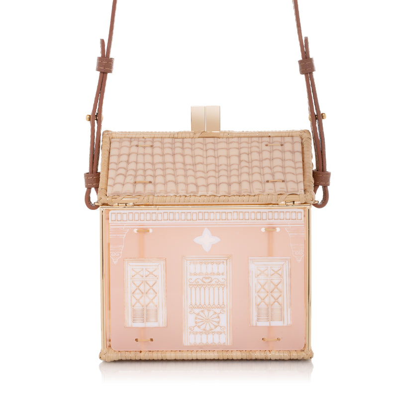 Bolsa autoral em acrílico e vime trançado, com formato de casa e estrutura dourada, feita artesanalmente no Brasil.