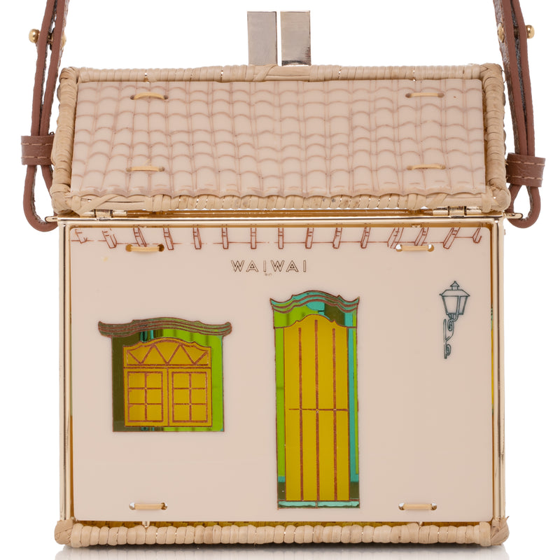 Bolsa autoral em acrílico nude e vime natural, com fachada colonial e estrutura dourada banhada a ouro.