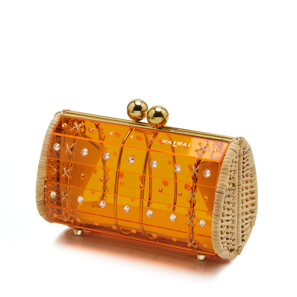 Clutch estruturada em acrílico laranja translúcido, aplicações geométricas, detalhes em palha nas laterais e fecho dourado esférico.