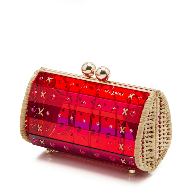 Clutch estruturada em acrílico vermelho translúcido, aplicações geométricas, detalhes laterais em palha e fecho dourado esférico.