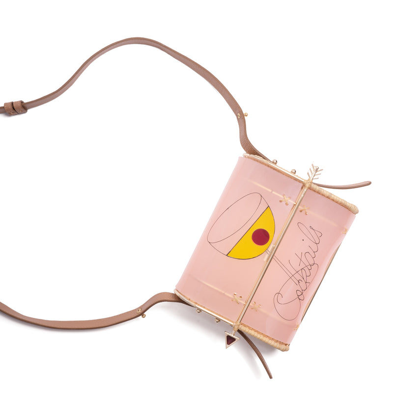 Clutch artesanal em acrílico rosa translúcido, com desenho de coquetel, palavra “Cocktails” e fecho metálico de flecha dourada.