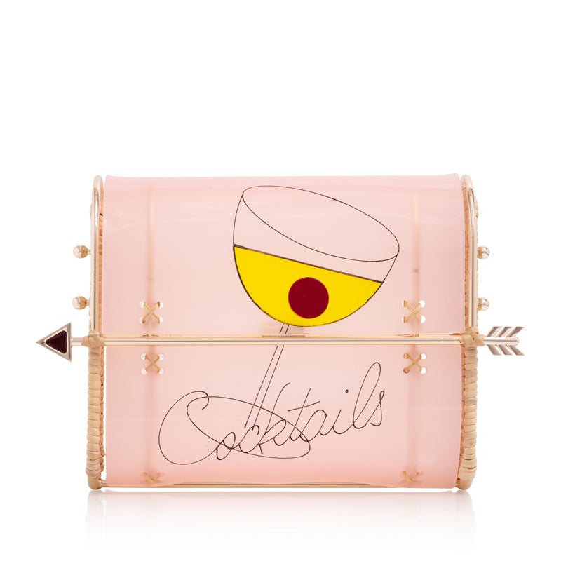 Bolsa clutch estruturada em acrílico rosa, decorada com taça de coquetel em amarelo com detalhe vermelho, inscrição “Cocktails” e fecho dourado em formato de flecha.