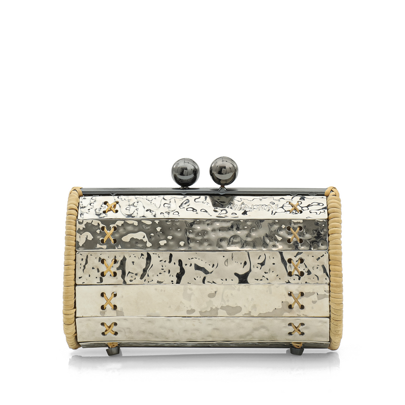 Clutch estruturada em metal prateado martelado com laterais em rattan, detalhe de costura em X e fecho esférico metálico.