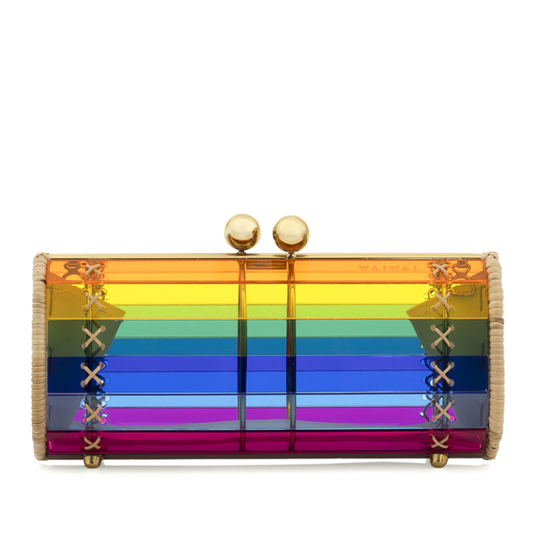 Bolsa clutch estruturada em acrílico com efeito arco-íris translúcido em listras horizontais coloridas. Laterais em rattan natural, ferragens douradas e fecho superior com esferas metálicas douradas.