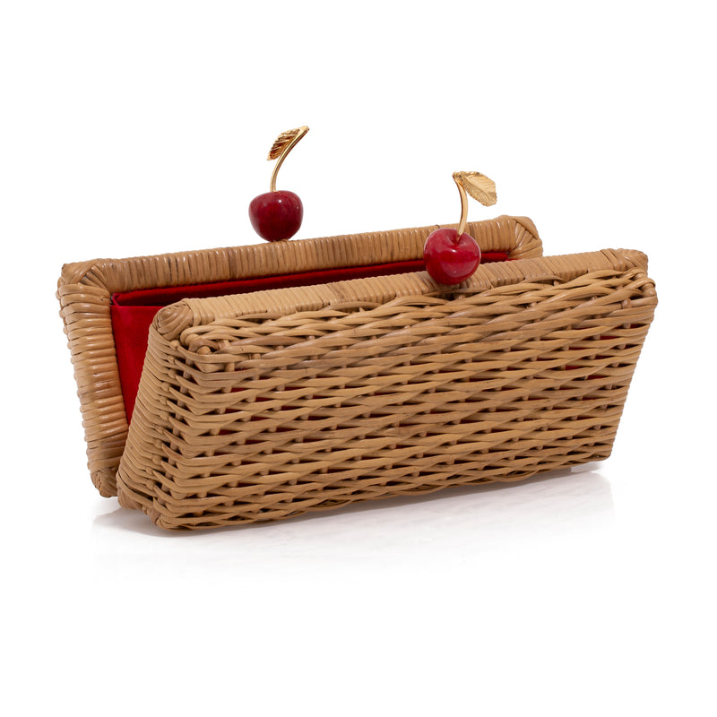 Clutch retangular em rattan natural, fecho em forma de cerejas vermelhas e folhas douradas.