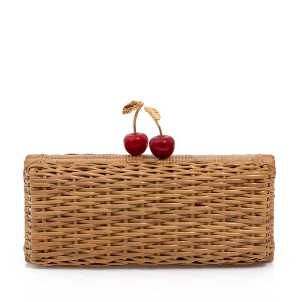 Clutch retangular em rattan natural com fecho em formato de cerejas vermelhas e folhas douradas.