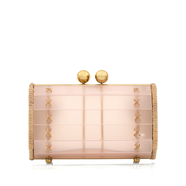 Bolsa clutch pequena estruturada em acrílico rosa fosco, com laterais em rattan natural e ferragens douradas. Fecho superior com duas esferas metálicas douradas, design compacto e sofisticado.