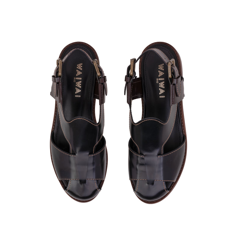 Sandália em couro preto com design fechado, fivela lateral ajustável e solado em madeira com acabamento sofisticado.