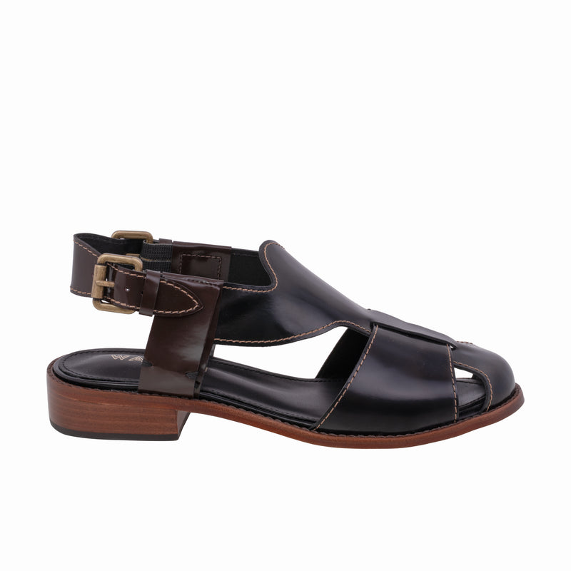 Sandália em couro preto, com design fechado, fivela lateral ajustável e solado de madeira com acabamento sofisticado.