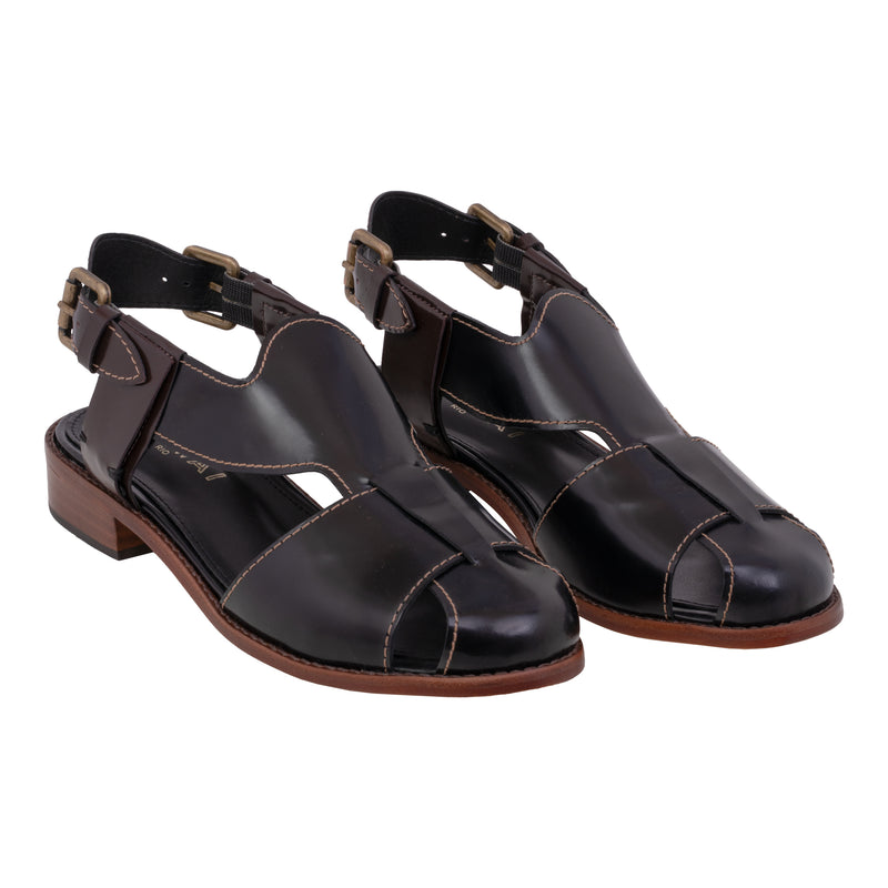 Sandália em couro preto, com design fechado e fivela lateral ajustável. O solado em madeira recebe um acabamento sofisticado que traduz elegância.