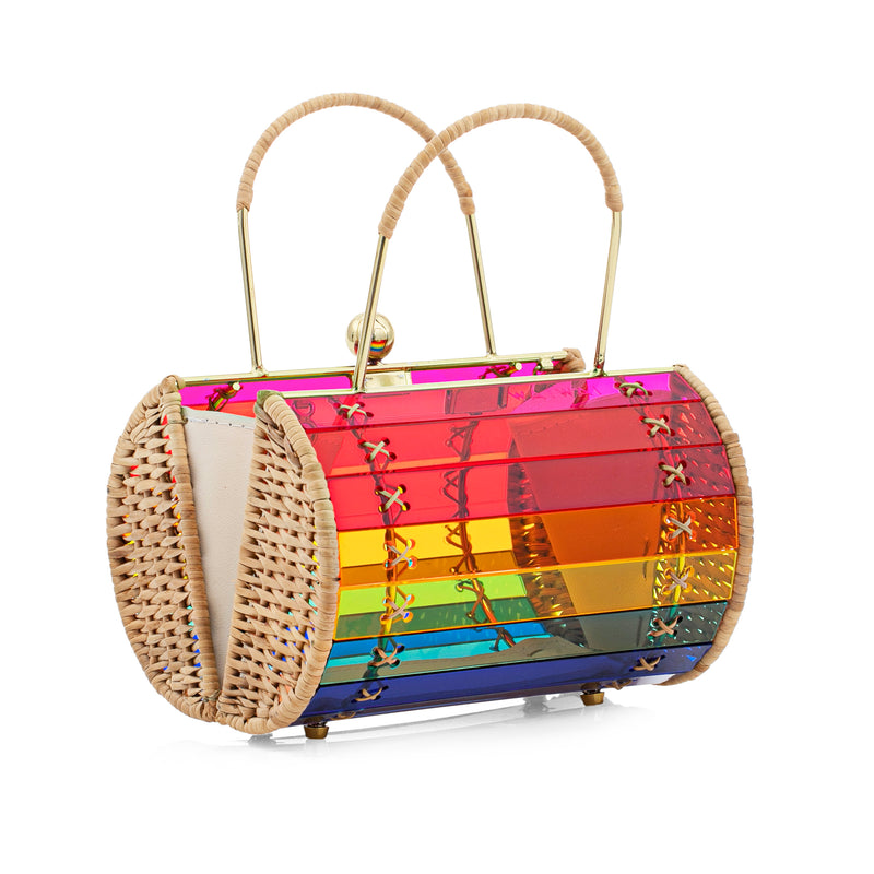 Bolsa artesanal em acrílico arco-íris estruturado, com laterais em rattan, fecho metálico dourado e alça rígida também dourada. Geometria vibrante em destaque.