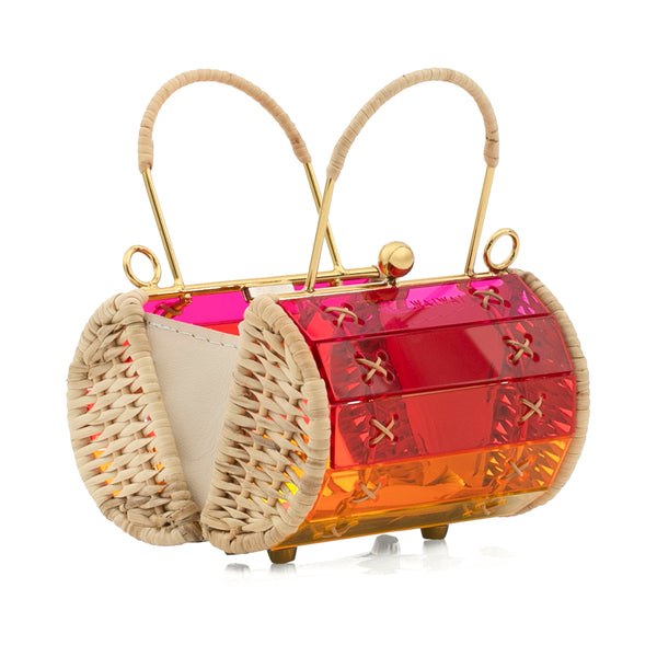 Bolsa em acrílico estruturado com efeito degradê arco-íris do vermelho ao verde, laterais em palha trançada, fecho esférico dourado e alça de mão em palha.