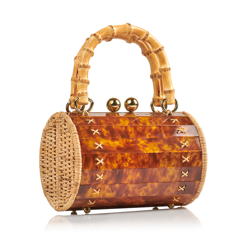 Bolsa box estruturada em acrílico marrom marmorizado com laterais em rattan, detalhe de costura em X dourado, alça rígida em bambu e fecho esférico metálico dourado.