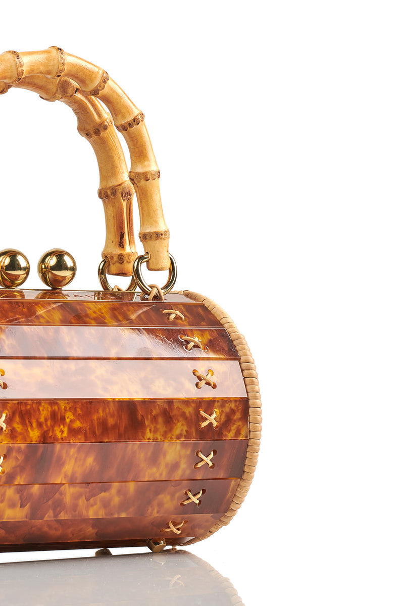 Bolsa box estruturada em acrílico marrom marmorizado com laterais em rattan, detalhe de costura em X dourado, alça rígida em bambu e fecho esférico metálico dourado.