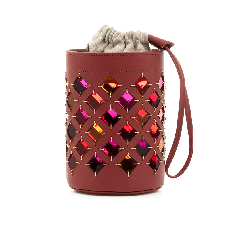 Bolsa bucket em couro vinho com recortes geométricos em forma de losango, interior colorido espelhado, alça longa regulável e fecho por cordão.
