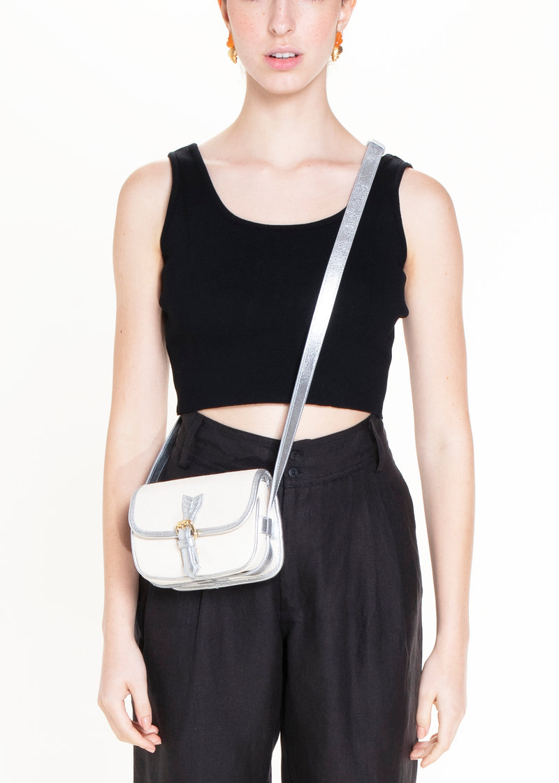 Bolsa em canvas cru com couro prateado metálico e detalhe de fivela dourada, ideal para ser usada na cintura como pochete ou no ombro como crossbody.