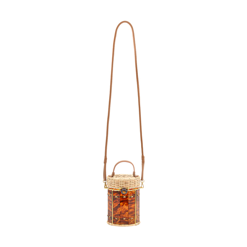 Bolsa estruturada em rattan e acrílico marmorizado em tonalidade âmbar, formato cilíndrico, alça curta em couro marrom e fecho dourado.