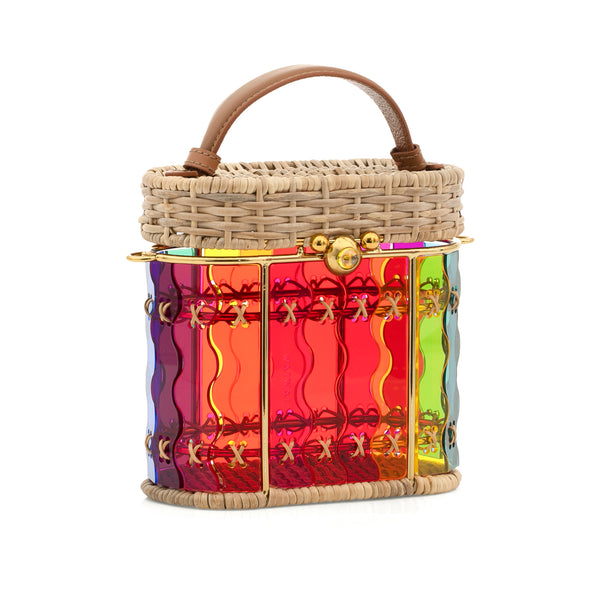 Bolsa em acrílico colorido estruturada, com padrão arco-íris ondulado, laterais em rattan natural, ferragens douradas e alça curta em couro marrom.