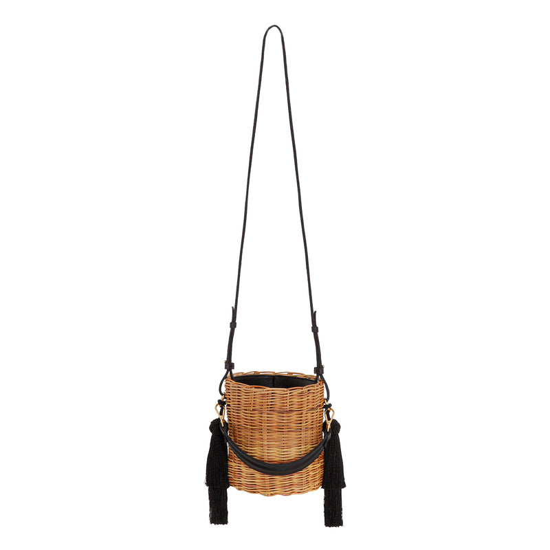 Bolsa tiracolo estruturada em rattan natural com alça longa em couro preto e detalhes em tassels pretos laterais.