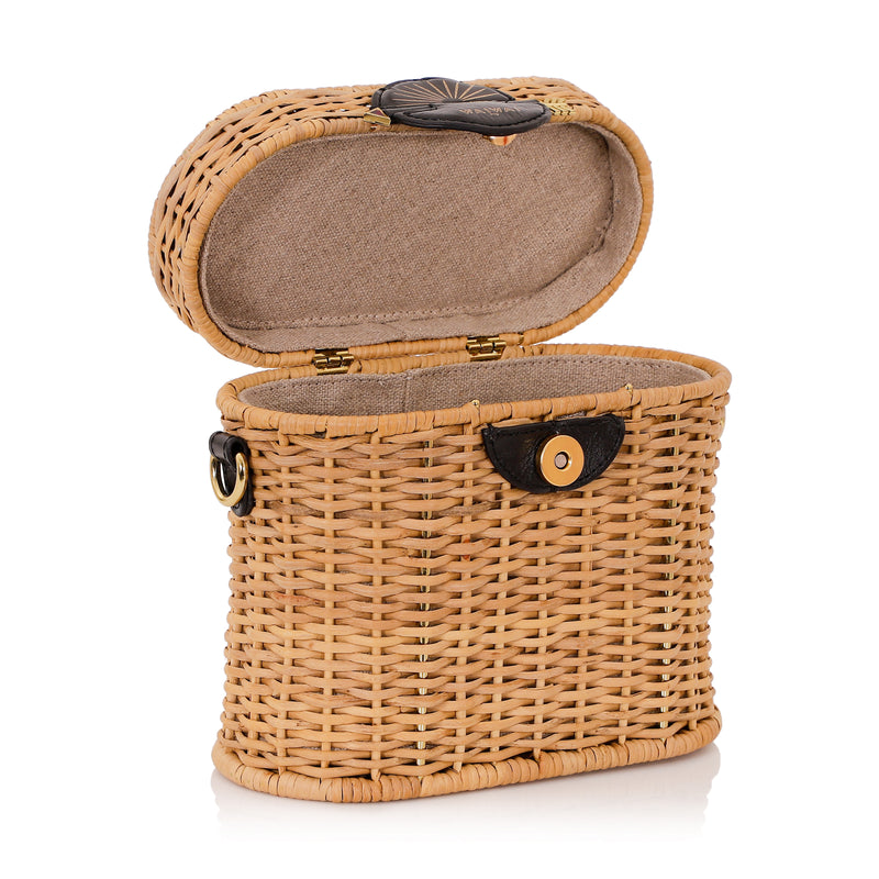Bolsa estruturada em vime natural com alça curta em couro preto e fecho redondo em couro com detalhe em baixo-relevo dourado em formato de sol nascente.