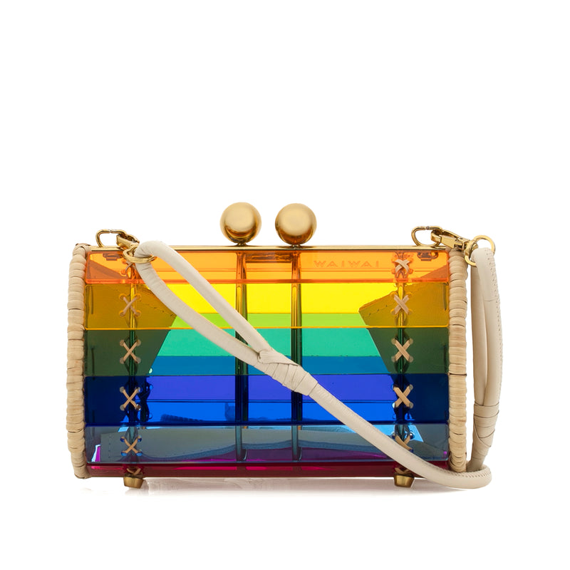 Bolsa clutch em acrílico translúcido com listras arco-íris horizontais, laterais em rattan natural, ferragens em dourado e fecho superior esférico.