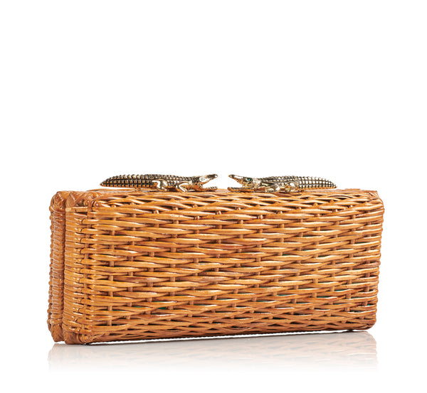 Clutch retangular em rattan natural com fecho metálico em formato de dois jacarés dourados com olhos verdes.