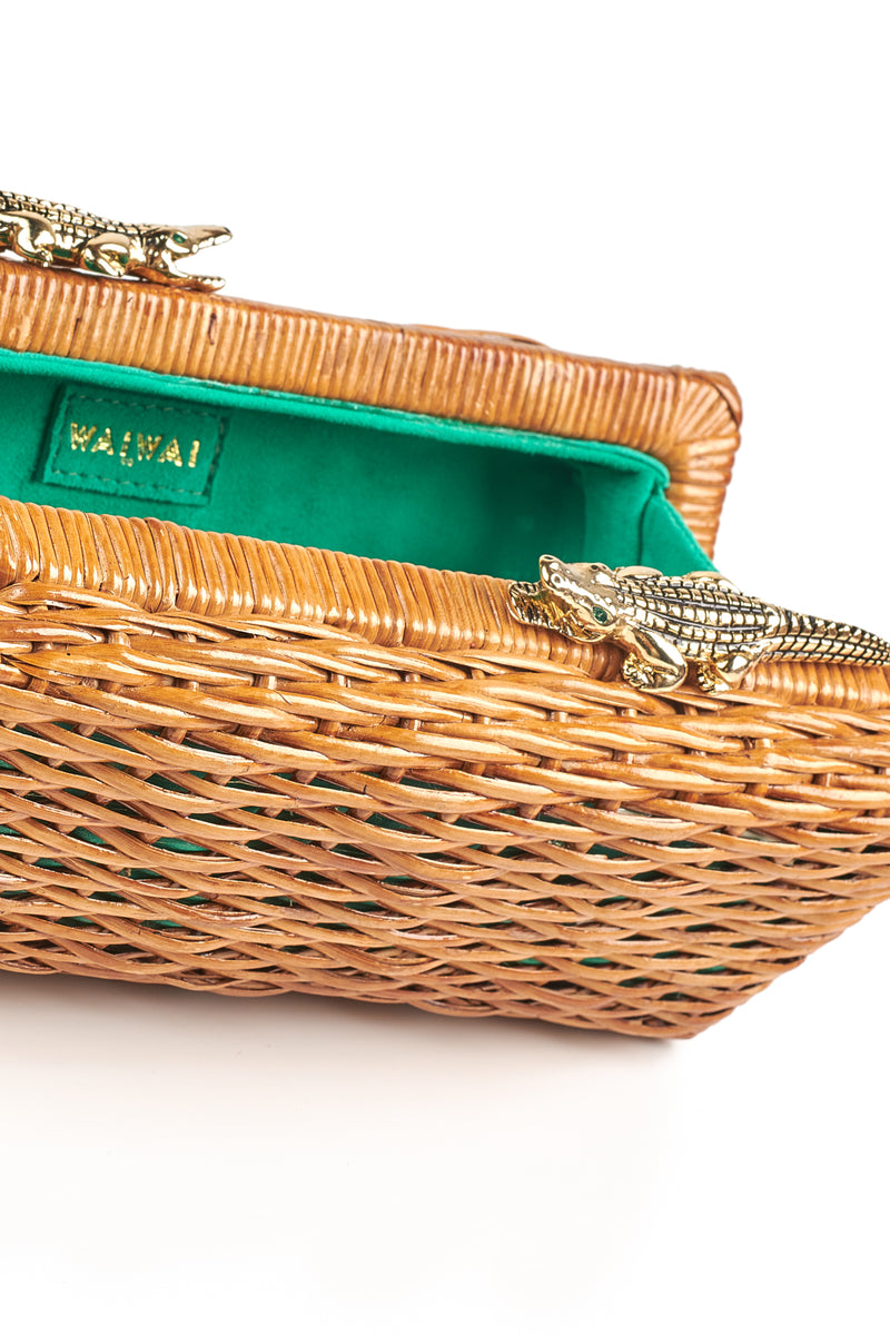 Clutch retangular em rattan natural com fecho metálico em formato de dois jacarés dourados com olhos verdes.