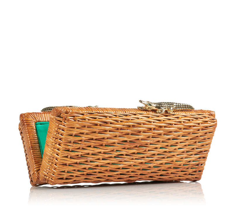 Clutch retangular em rattan natural com fecho metálico em formato de dois jacarés dourados com olhos verdes.