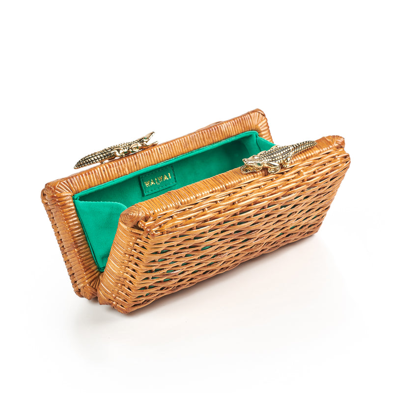 Clutch retangular em rattan natural com fecho metálico em formato de dois jacarés dourados com olhos verdes.