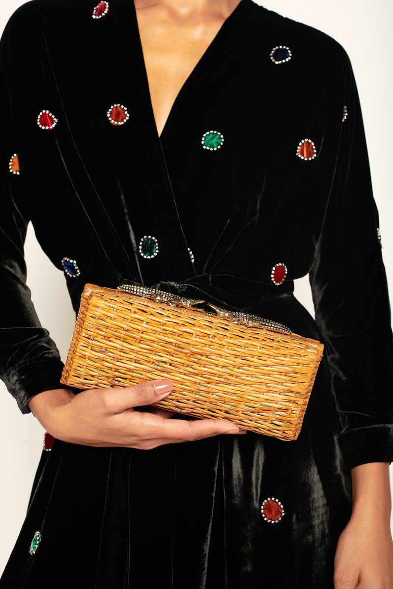 Clutch retangular em rattan natural com fecho metálico em formato de dois jacarés dourados com olhos verdes.