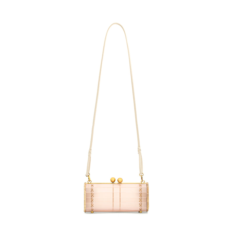 Bolsa clutch em acrílico rosa fosco, laterais em rattan natural, ferragens metálicas douradas e fecho de esferas no topo. Design elegante.