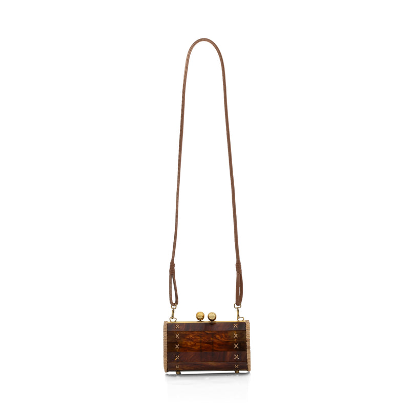 Bolsa clutch estruturada em acrílico tartaruga marrom, laterais de rattan natural, ferragens em dourado e fecho esférico. Atemporal e elegante.