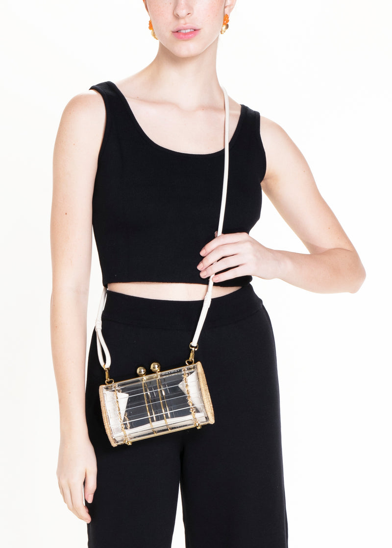 Bolsa clutch em acrílico transparente pequeno, estruturada com laterais em rattan, detalhes em couro bege e ferragens douradas com fecho esférico.